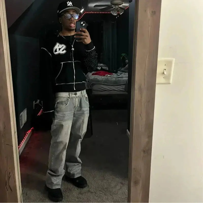 Man wearing 2000s punk rock street hip-hop black diamond print zip-up hoodie with baggy jeans in bedroom mirror selfie